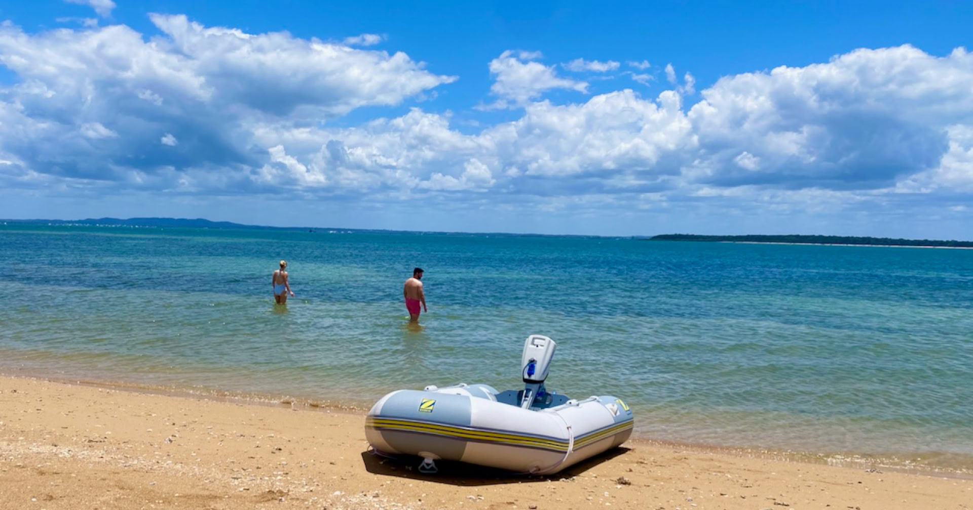 Guests swimming at Bird Islet Sandbar on sailing yacht Curlew Escape on a private yacht charter at Moreton Bay, Brisbane.