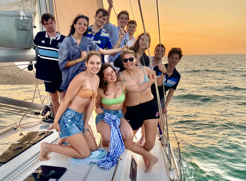 Friends enjoying lunch around the cockpit table while on a sailing charter in Moreton Bay.