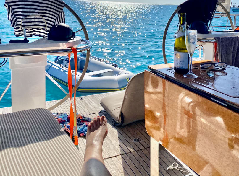 Friends enjoying lunch around the cockpit table while on a sailing charter in Moreton Bay.